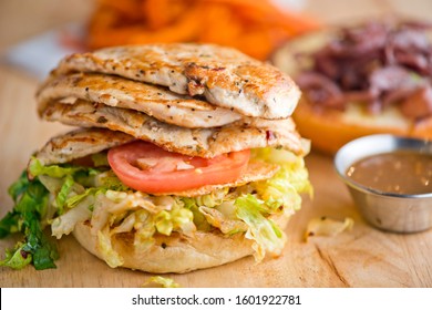 Grilled Chicken Breast Sandwich. Farm Fresh range free chicken served with pickled red onions shredded lettuce and heirloom tomatoes served on toasted sesame seed bun. Classic American Diner dinner.  - Shutterstock ID 1601922781