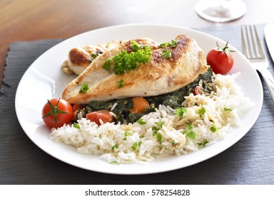 Grilled chicken breast with vegetables, rice and cherry tomatoes. Healthy eating scene, grilled chicken on a wooden table. - Powered by Shutterstock