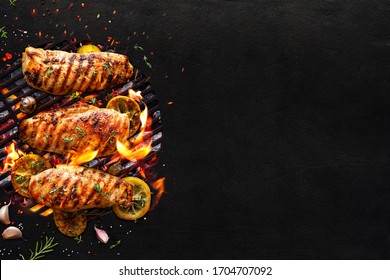 Grilled chicken breasts on a grill plate on black background with copy space, top view. Bbq background - Shutterstock ID 1704707092