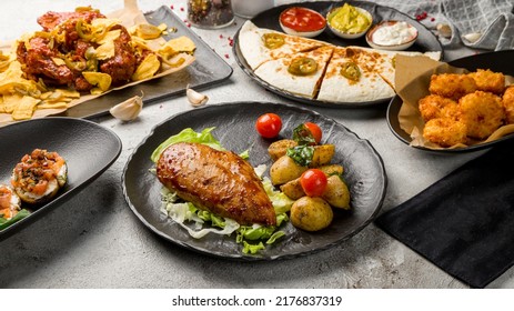 Grilled Chicken Breasts, Chicken Wings, Quesadilla With Chicken And Sauces On Tables