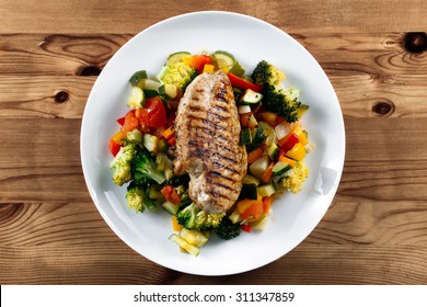 Grilled Chicken Fillet, Breast With Cooked Vegetable Tomatoes, Carrots, Peppers, Courgettes, Brocoli On Plates