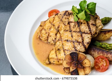 Grilled chicken fillet with french fries and asparagus - Powered by Shutterstock