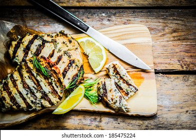 Grilled Chicken With Herbs And Lemon On Wooden Background