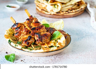 Grilled chicken kebabs (chicken skewers) with herbed garlic butter naan tortillas and Greek tzatziki sauce. Delicious street food.

 - Powered by Shutterstock