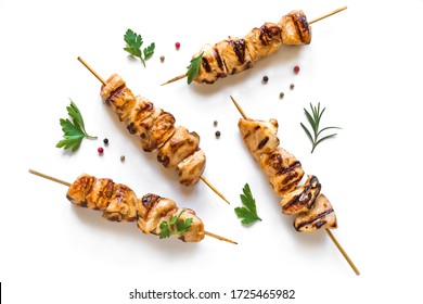 Las brochetas de pollo a la parrilla aisladas en un fondo blanco, vista superior. Carne de cerdo, pollo o pavo shish kebab con hierbas y especias.