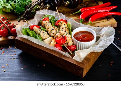 Grilled chicken skewers shish kebab with ketchup on wooden table