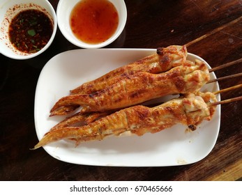 Grilled chicken wing with chili sauce  and wooden background