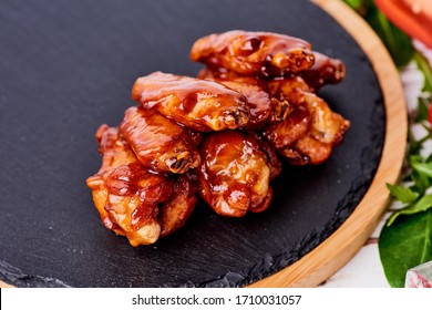 Grilled Chicken Wings On Black Stone Background.