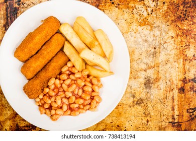 Grilled Cod Fish Fingers With Chunky Chips And Baked Beans In Tomato Sauce On A Distressed Oven Or Baking Tray With Copy Space