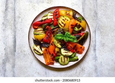 Grilled colorful vegetable : bell pepper, zucchini, eggplant on a plate over light grey slate, stone or concrete background. Top view with copy space. - Shutterstock ID 2080680913