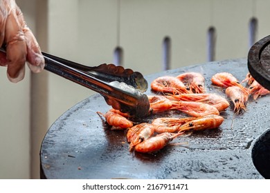 Grilled Cooked Shrimp And Hand With Barbecue Tongs. Grilled Fish Food Outdoor Summer Family Party Picnic In The Park.