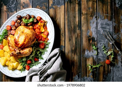 Grilled Cooked Whole Chicken With Vegetable Garnish Grilled Bell Pepper, Onion, Baked Potatoes, Cherry Tomatoes, Mushrooms, Herbs In Ceramic Plate Over Dark Wooden Background. Flat Lay. Copy Space