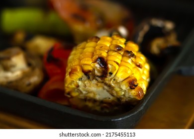 Grilled Corn Cob With Butter And Salt And Different Vegetables On Grill Pan, Close-up