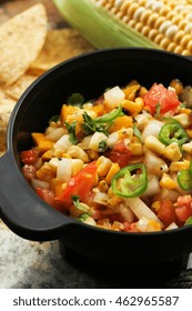 Grilled Corn Mango Tomato Salsa With Chips Served In A Black Salsa Bowl, Selective Focus