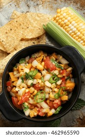 Grilled Corn Mango Tomato Salsa With Chips Served In A Black Salsa Bowl, Selective Focus