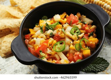 Grilled Corn Mango Tomato Salsa With Chips Served In A Black Salsa Bowl, Selective Focus