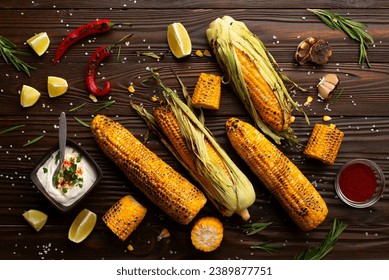 Grilled corn on the cob on kitchen table flat lay background