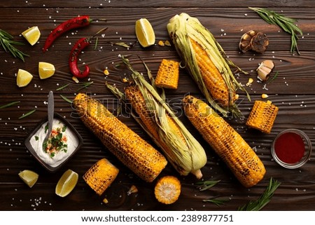 Grilled corn on the cob on kitchen table flat lay background