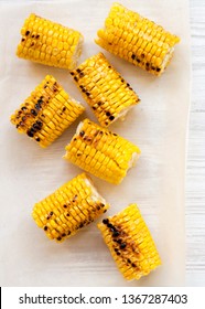 Grilled Corn On The Cob Over White Wooden Surface, Top View. Summer Food. From Above, Overhead, Flat Lay. Close-up.