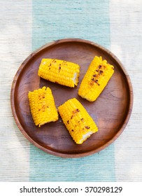 Grilled Corn On The Cob With Salt And Butter On A Wooden Plate Top View Copy Space