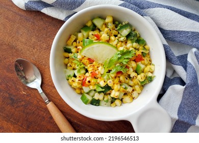 Grilled Corn Salad With Cucumber, Coriander, Chili And Lime. White Plate. Wooden Table.