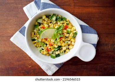 Grilled Corn Salad With Cucumber, Coriander, Chili And Lime. White Plate. Wooden Table.