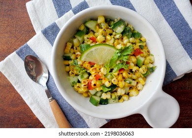 Grilled Corn Salad With Cucumber, Coriander, Chili And Lime. White Plate. Wooden Table.