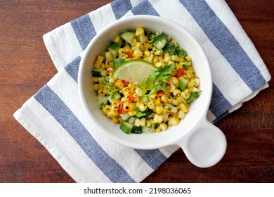 Grilled Corn Salad With Cucumber, Coriander, Chili And Lime. White Plate. Wooden Table.