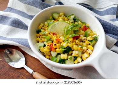 Grilled Corn Salad With Cucumber, Coriander, Chili And Lime. White Plate. Wooden Table.