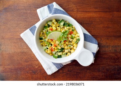 Grilled Corn Salad With Cucumber, Coriander, Chili And Lime. White Plate. Wooden Table.