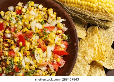 Grilled Corn Salsa Served In Wooden Plate With Chips, Overhead View