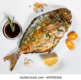 Grilled Dorado Fish With Greens And Lemon On Black Background Isolated. Healthy Food. Top View