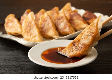 Grilled dumplings dipped in soy sauce with chopsticks - Powered by Shutterstock