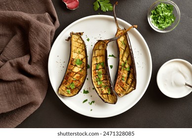 Grilled eggplant (aubergine) on plate over dark stone background. Top view, flat lay - Powered by Shutterstock