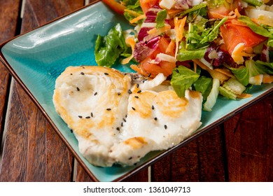 Grilled fish fillet with a vegetable salad,