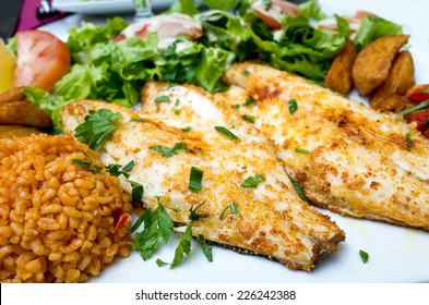 Grilled Fish And Rice With Many  Vegetables And French Fries