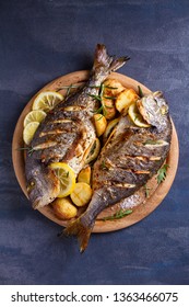 Grilled Fish With Roasted Potatoes, Lemon And Rosemary On Wooden Tray. View From Above, Top