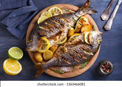 Grilled Fish With Roasted Potatoes, Lemon And Rosemary On Wooden Tray. View From Above, Top