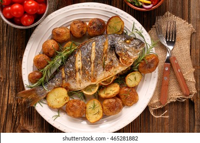 Grilled Fish With Roasted Potatoes And Vegetables On The Plate


