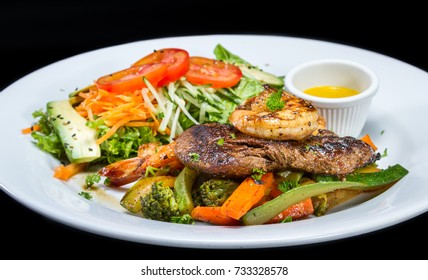 Grilled Flank Steak And Jumbo Shrimp Served With A Side Salad