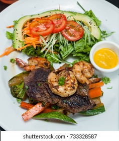 Grilled Flank Steak And Jumbo Shrimp Served With A Side Salad