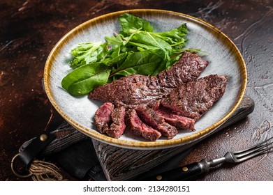 Grilled Flap steak flank cut and Machete skirt steak on grill with herbs. Gray background. Top view