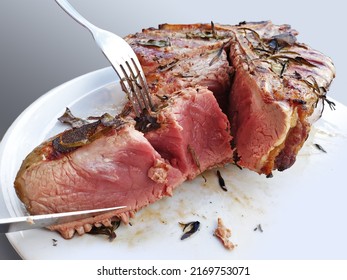 Grilled Florentine T-bone beef steak cut in a round white plate on white background