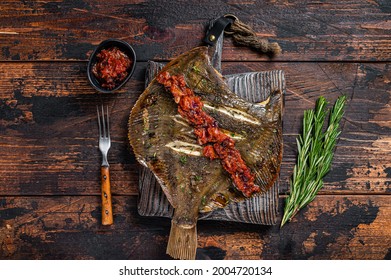 Grilled Flounder Or Plaice With Tomato Sauce On Wooden Cutting Board. Dark Wooden Background. Top View