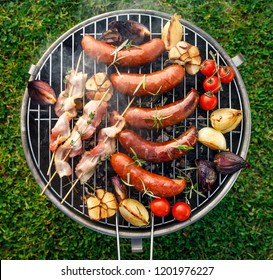 Grilled Food. Grilled Pork Sausage, Bacon And Vegetables On The Grill Plate, Top View, Outdoor. Barbecue, Bbq