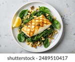 Grilled Halibut with Spinach, leeks and Pine Nuts top view on white background.