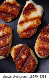 Grilled Halloumi Hard Cheese On A Black Plate. Vertical Orientation. Close Up.