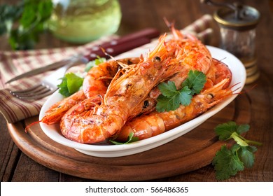 Grilled King Prawns Or Shrimps With Parsley On White Plate On Dark Rustic Wooden Table