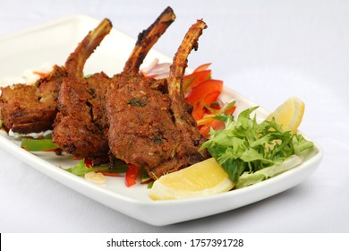 Grilled lamb chops marinated in Indian spices and served with salad and sauces