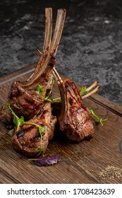 Grilled lamb ribs on cutting board. Hot rack of lamb with spices and condiments. Top view on wooden table - Shutterstock ID 1708423639